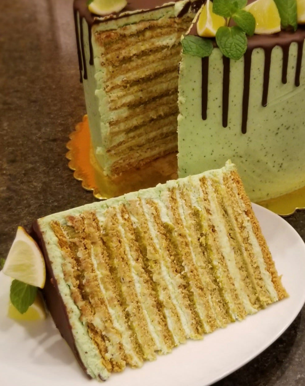 Slice of mint lime honey cake showing numerous layers of filling.