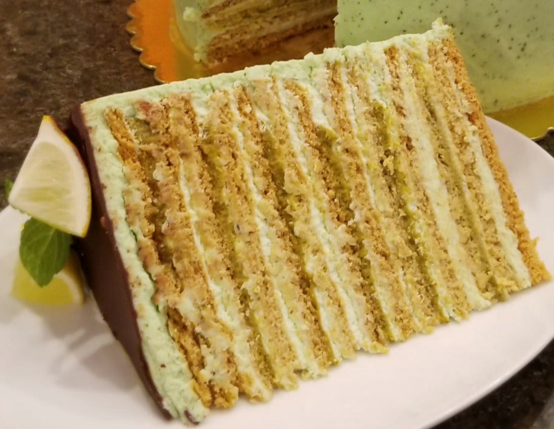 Close up of a slice of mint lime honey cake showing numerous layers of filling.