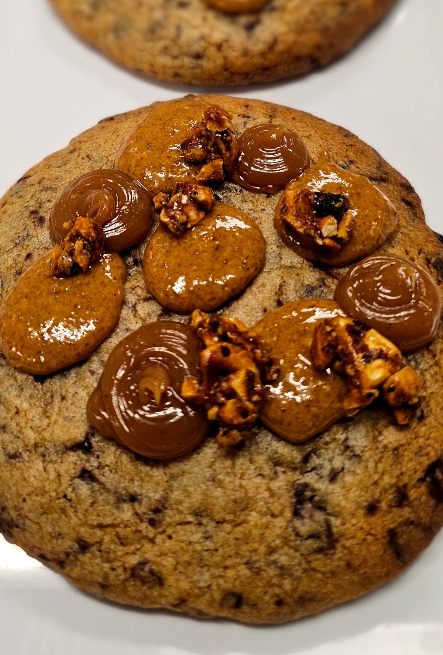 Large chocolate chip cookie with dollops of caramel and praline on top