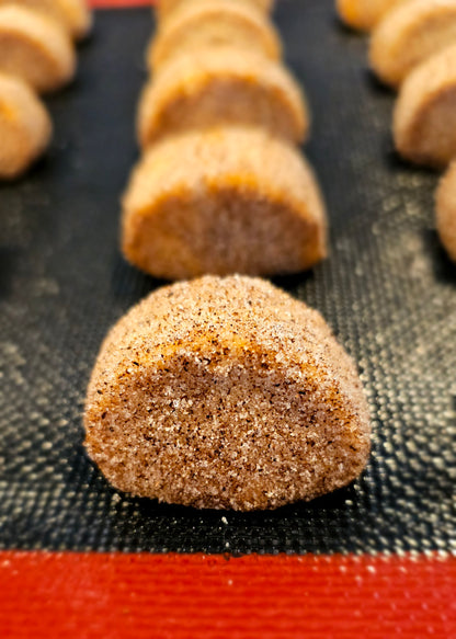 A tray of vanilla kipferl cookies covered in vanilla sugar, arranged in rows.