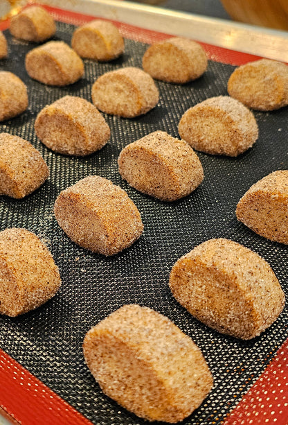 A tray of vanilla kipferl cookies covered in vanilla sugar, arranged in rows.