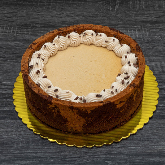 Cappuccino Cheesecake with dual color crust and decorated with chantilly cream in a scalloping pattern.