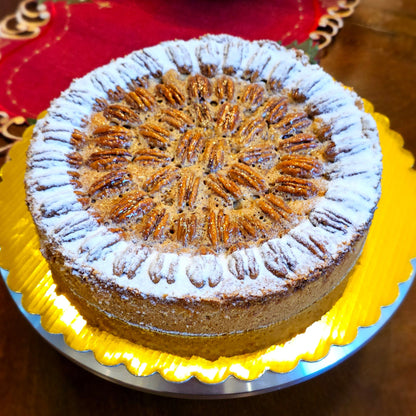 A freshly baked Apple Pecan Charlotte dessert topped with powdered sugar, presented on a yellow plate.