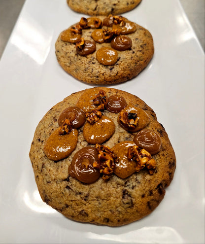 Large chocolate chip cookie with dollops of caramel and praline on top