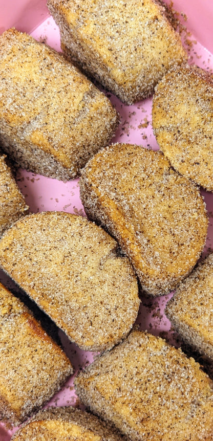 Several vanilla kipferl cookies covered in vanilla sugar, arranged in rows.