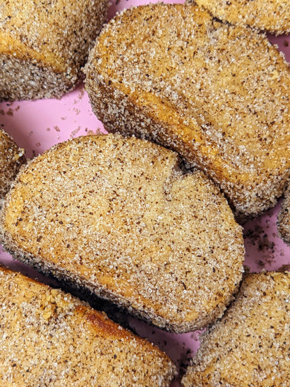 Closeup of vanilla kipferl cookies covered in vanilla sugar, arranged in rows.