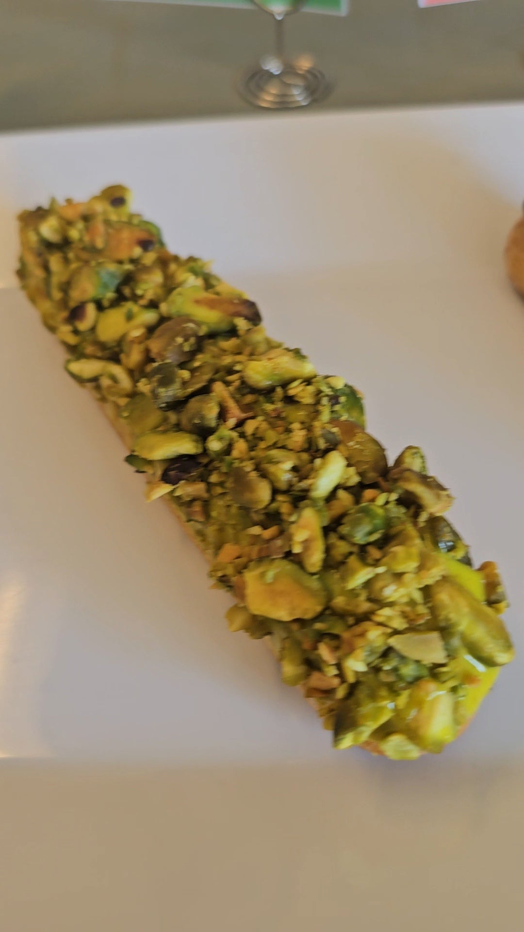 Green pistachio eclair on a white surface