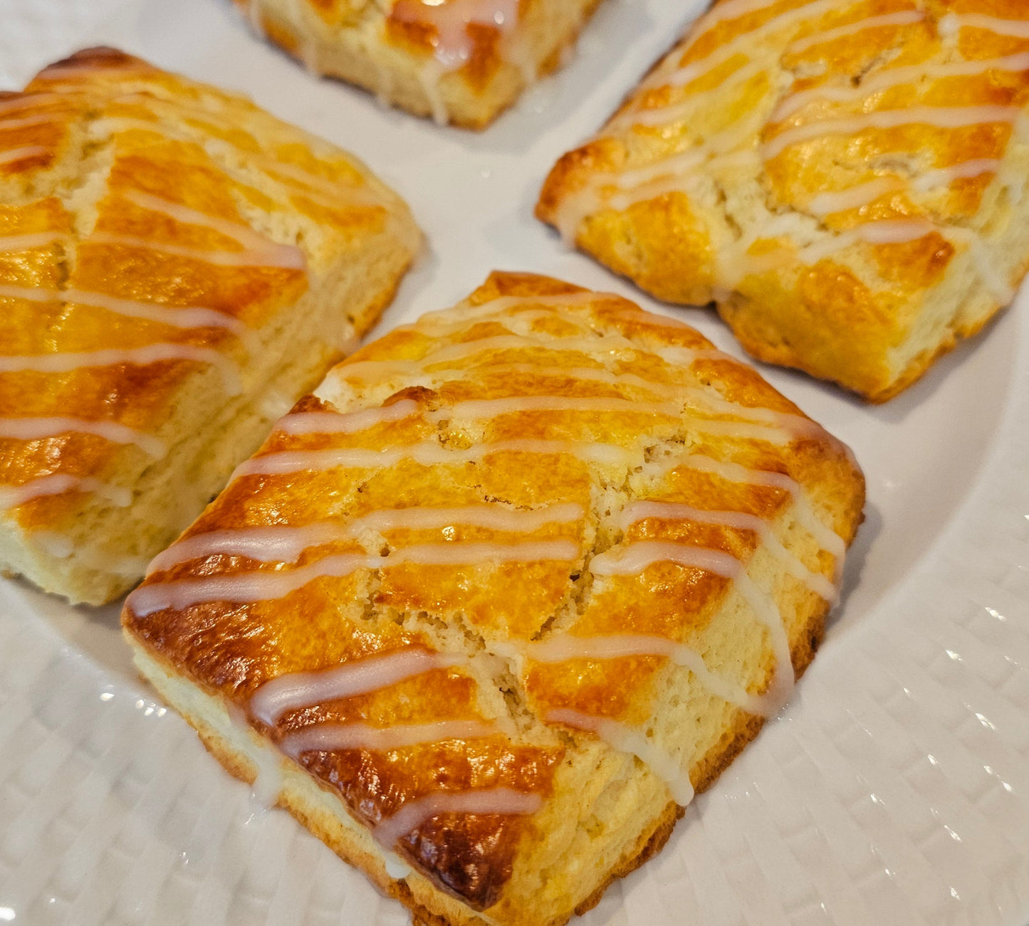 Square scones with glaze on a white plate.