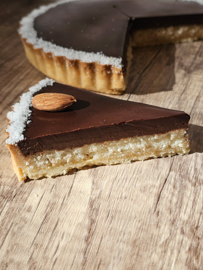 Close-up of a chocolate dessert with almonds on a wooden surface