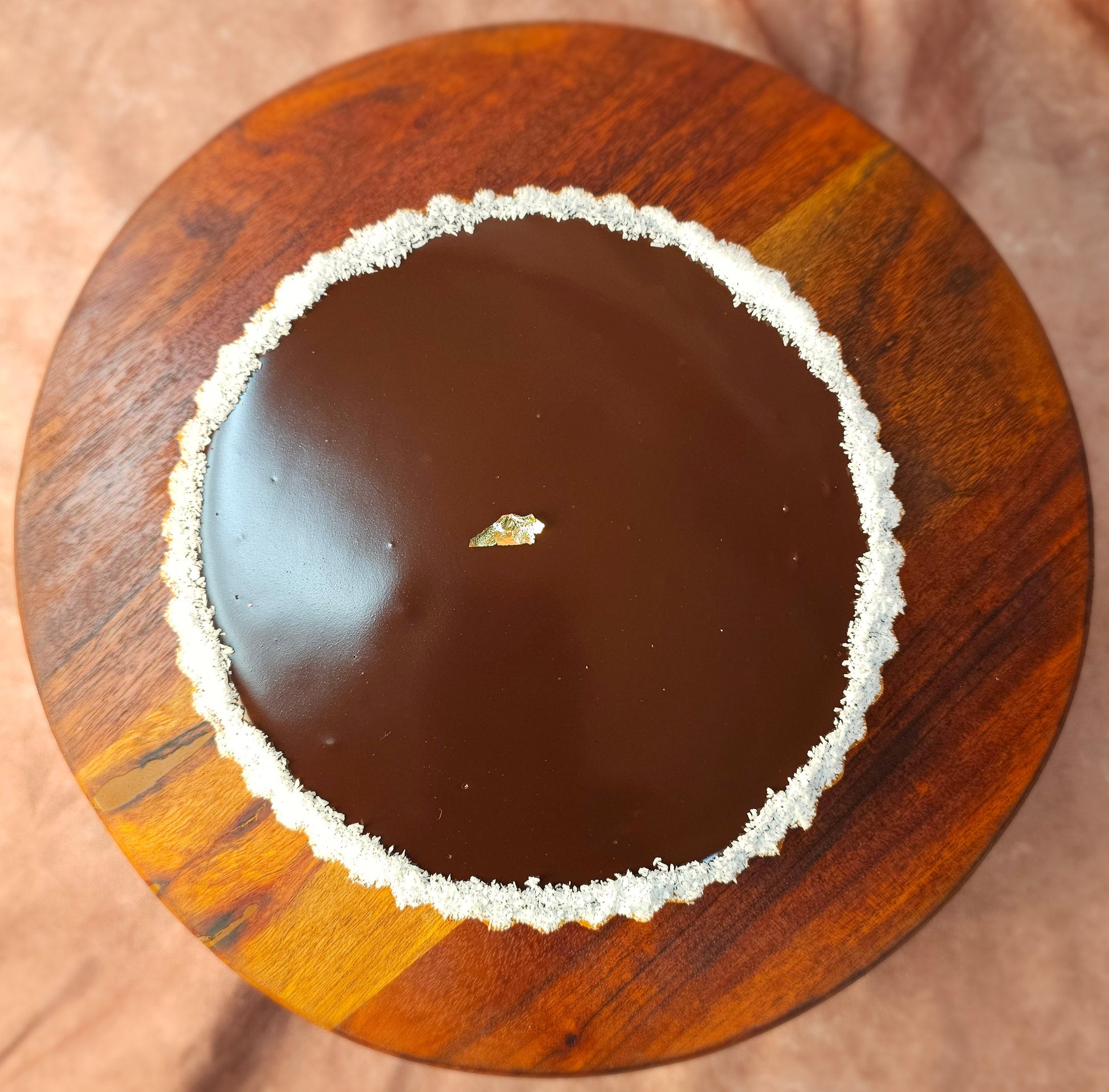 Top view of a chocolate tart with shredded coconut around the edges.