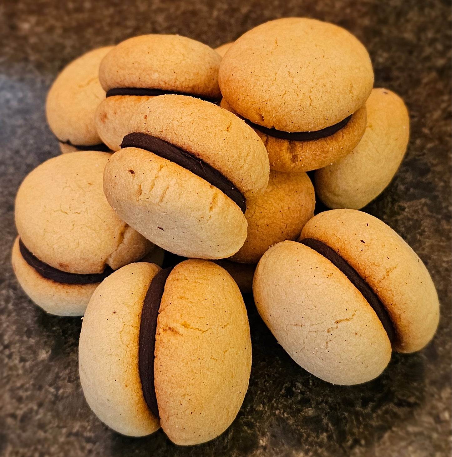 Cookies with chocolate filling on a textured surface