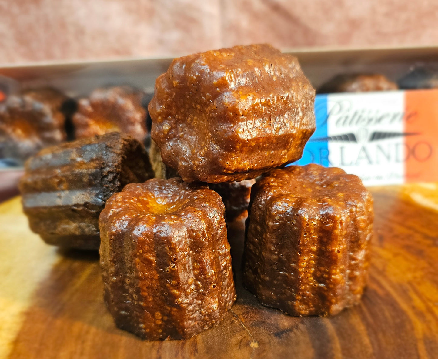 Canele stacked on a wooden board.