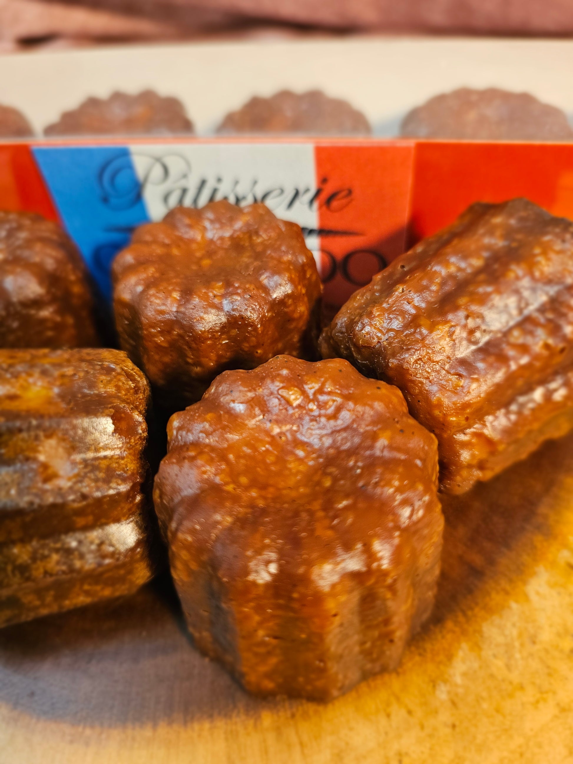 Close-up of caneles with a brand name visible on a wooden surface
