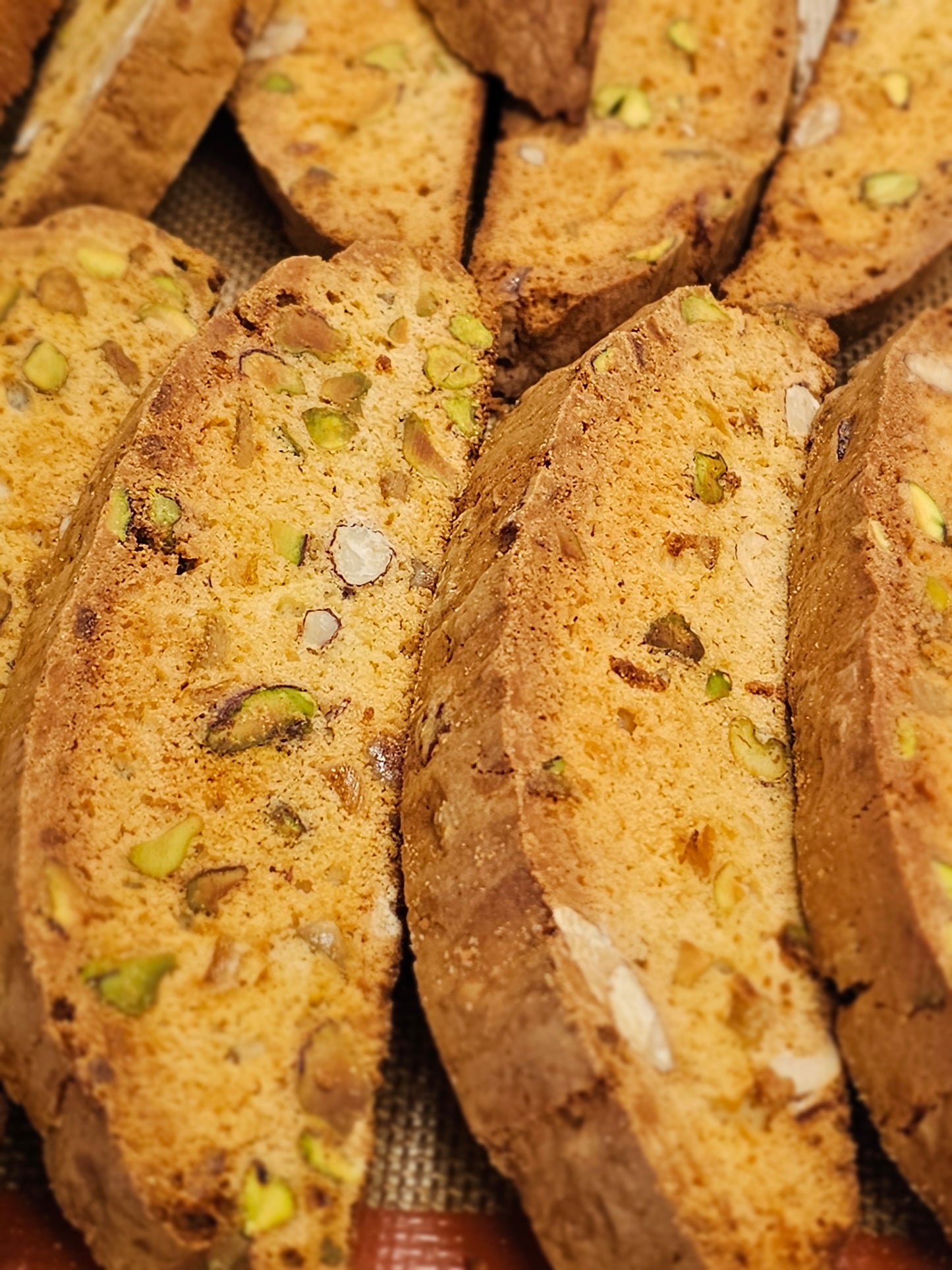 Close-up of stacked biscotti cookies with visible pistachios and almonds.